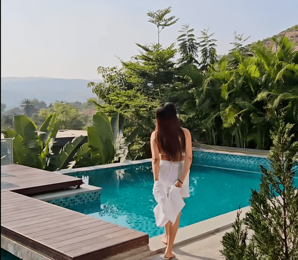 A woman gracefully entering a private infinity pool at a luxury villa in Udaipur.